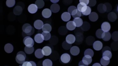Koyu arka plan üzerinde beyaz şenlikli ışıkları bokeh