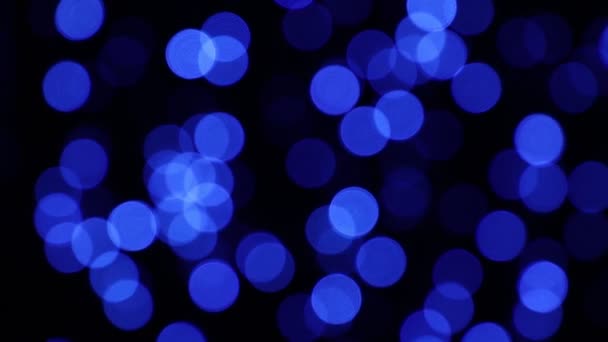 Blue festive lights bokeh over dark background — Stock Video