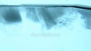 Mavi suya düşmüş açık buz küpleri yakın çekim