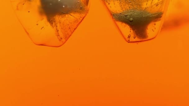 Ice cubes melt in tea or whiskey close up — Stock Video