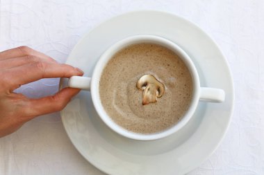 Kadın el champignon krem çorba kasesi tutarak