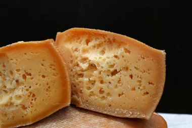 Siyah arka plan üzerinde blok yaşlı peynir kesmek