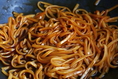 Asya karıştırın kızarmış udon erişte wok tavada yakın çekim
