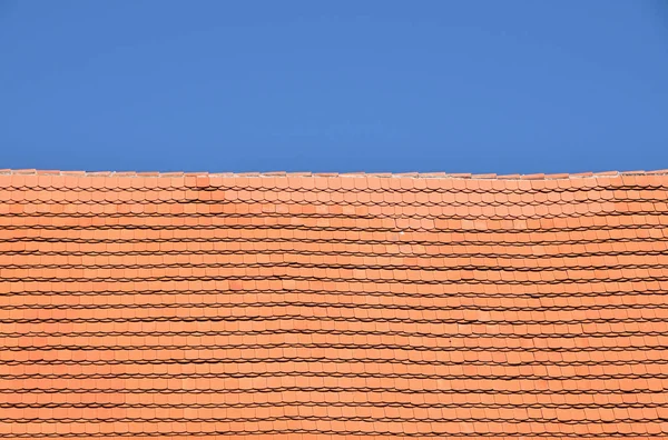 Красно-коричневая керамическая черепица над голубым небом — стоковое фото
