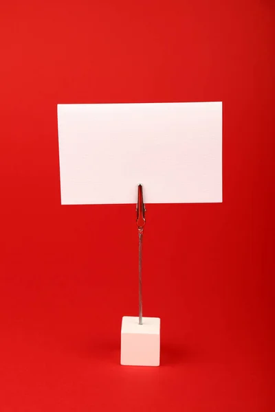 Signo de papel blanco en blanco sobre fondo rojo — Foto de Stock