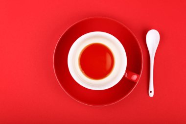 Boş bardak kırmızı bir arka plan üzerinde siyah çay