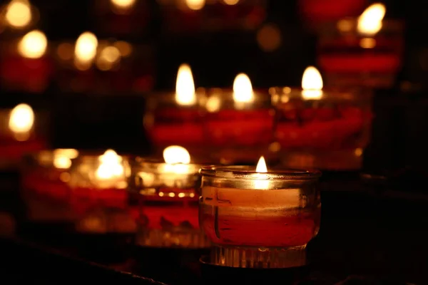 Bougies rouges brûlant dans l'église sombre gros plan — Photo