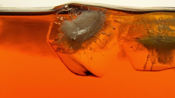 Cubos de gelo derreter em chá ou uísque de perto — Vídeo de Stock