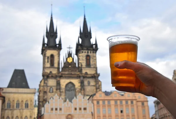 Člověk ruku ukazující pivní sklo nad pražské panoráma — Stock fotografie