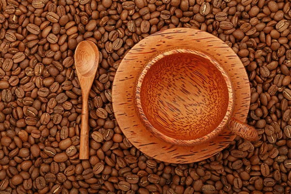 Empty coffee palm wood cup over coffee beans