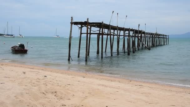 Antiguo muelle de madera en ruinas y barcos en la playa de arena mar — Vídeos de Stock