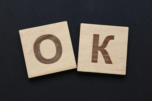 Palavra OK em sinais de madeira sobre preto — Fotografia de Stock