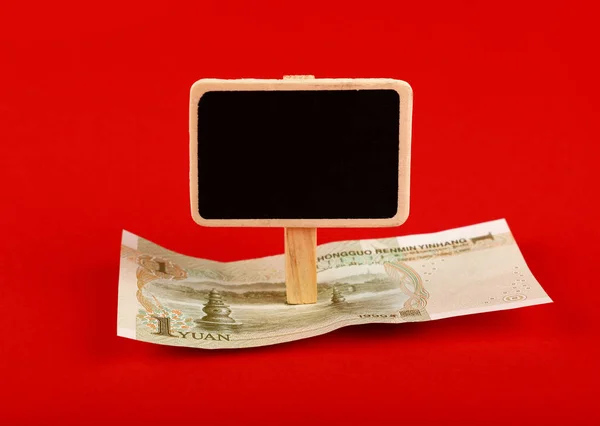 Yuan banknote and blackboard sign on red — Stock Photo, Image