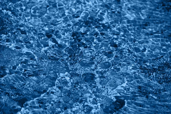 Correre onde d'acqua blu sulle pietre — Foto Stock