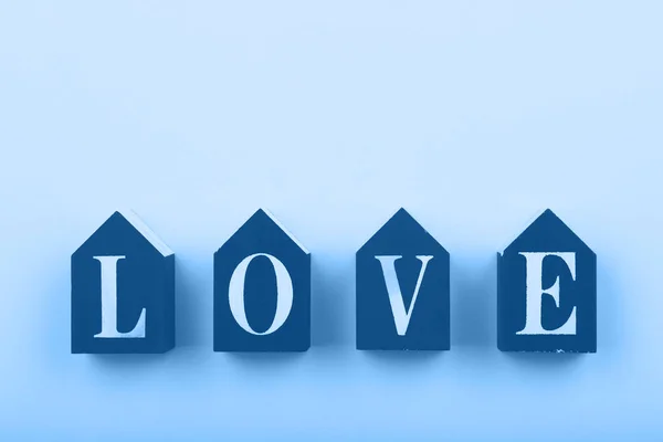 Cubos de madera con palabra LOVE sobre fondo azul — Foto de Stock