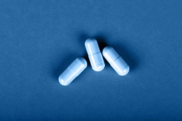 Cerrar tres pastillas de gel tapa sobre fondo azul — Foto de Stock