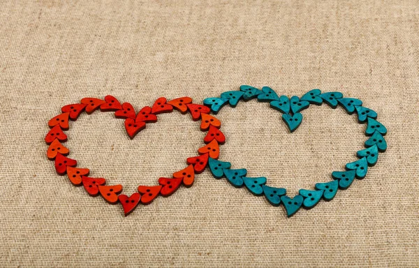 Два сердца в форме пуговиц на холсте — стоковое фото