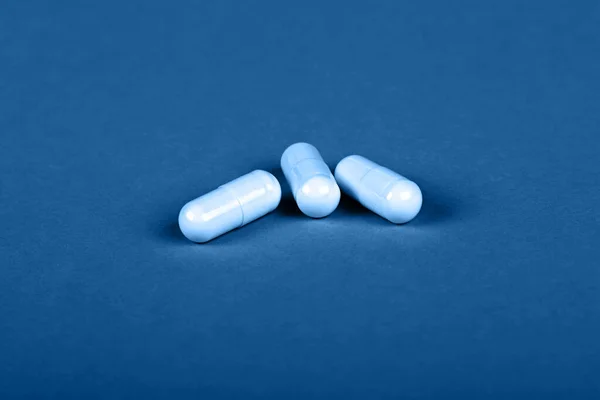 Cierre Tres Pastillas Gel Blanco Tapa Medicina Sobre Fondo Azul — Foto de Stock