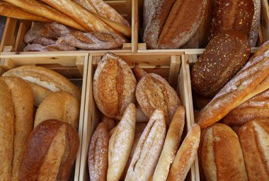Bir kaç çeşit taze buğday ekmeğini ve ekmeği pastanenin perakende vitrininde ahşap kutuda, yüksek açılı manzarada kapat.