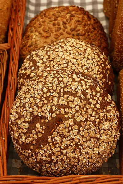 Close up selection of fresh bread loaves on retail display of bakery store, high angle view