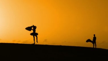 Sunset bulvarında bir kumsalda dans siluet