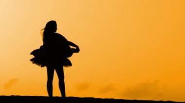 Sunset bulvarında bir kumsalda dans siluet