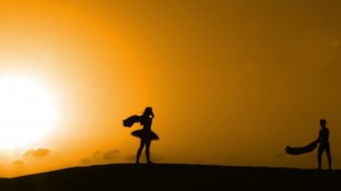 Sunset bulvarında bir kumsalda dans siluet