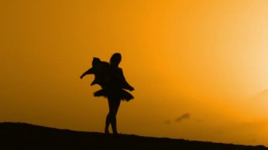Sunset bulvarında bir kumsalda dans siluet