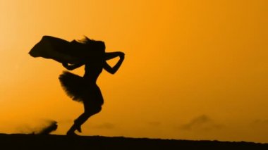 Sunset bulvarında bir kumsalda dans siluet