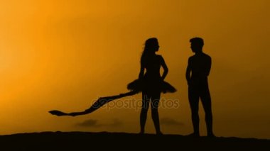 Sunset bulvarında bir kumsalda dans siluet