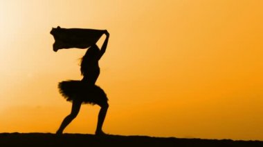 Sunset bulvarında bir kumsalda dans siluet
