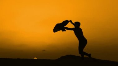 Sunset bulvarında bir kumsalda dans siluet