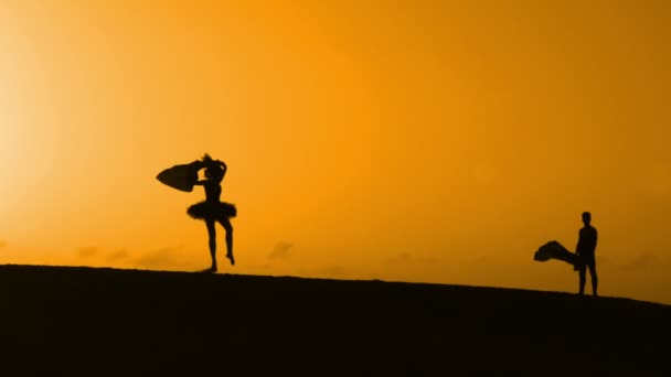 Silhueta dançando em uma praia no pôr do sol — Vídeo de Stock
