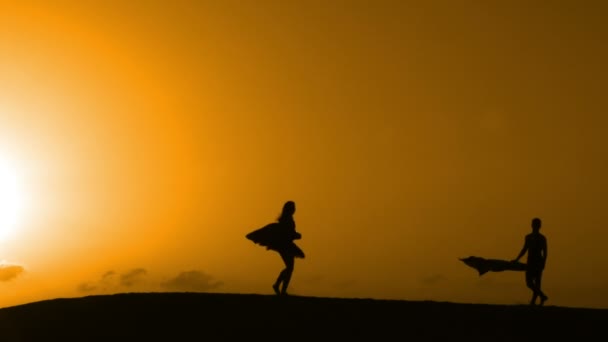 Silueta bailando en una playa al atardecer — Vídeos de Stock