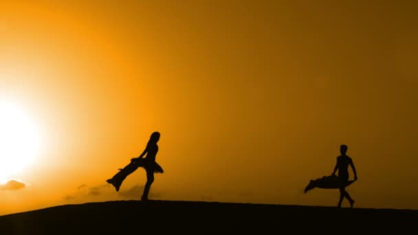 Silueta bailando en una playa al atardecer — Vídeos de Stock