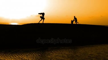 Sunset bulvarında bir kumsalda dans siluet