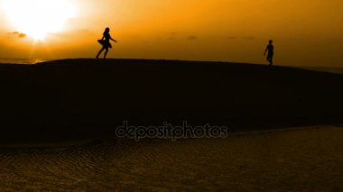 Sunset bulvarında bir kumsalda dans siluet