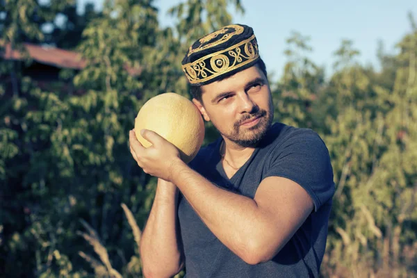 Jonge man met een rijpe meloen — Stockfoto