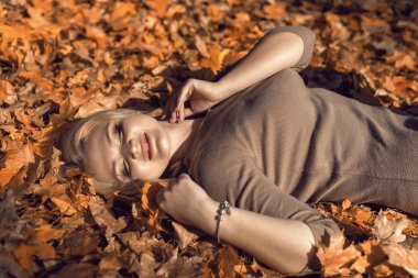 Parkta güzel bir sarışınla sonbahar yürüyüşü