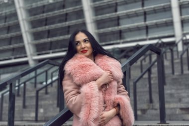 Şehirde pembe ceketli bir esmer.