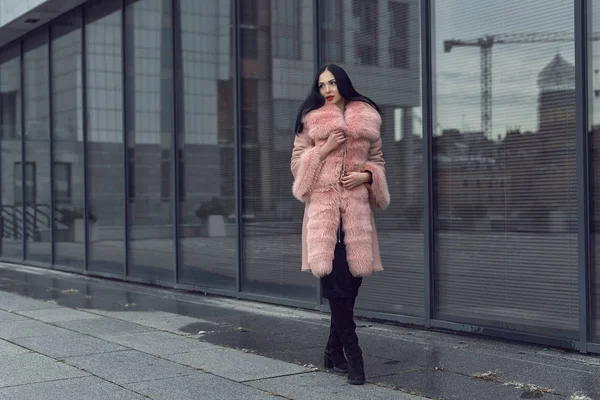 Brunetka w mieście w różowym płaszczu — Zdjęcie stockowe