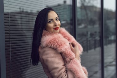 Şehirde pembe ceketli bir esmer.