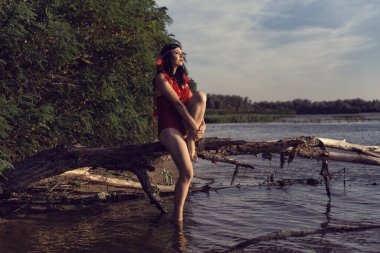 Kırmızılı genç kız nehir kenarında