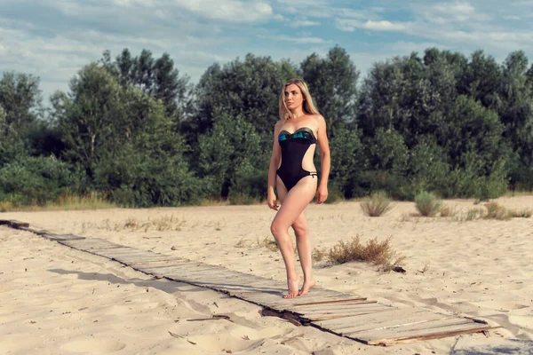 水着姿の女性と一緒にビーチを歩く — ストック写真