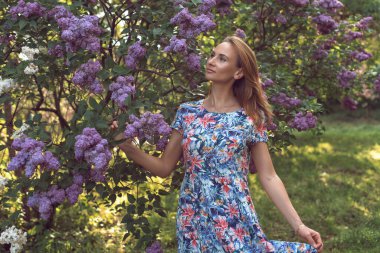 Leylak çiçeklenme mevsiminde genç bir kadınla yürü.