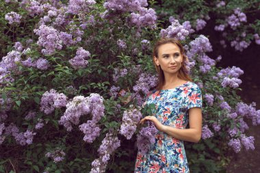 Leylak çiçeklenme mevsiminde genç bir kadınla yürü.