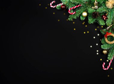 Üst görünüm köknar çerçeve, Noel ağacı sınırı, şenlikli dekor, yıldız konfetisi siyah üzerine kopya alanı olan konfeti düzeni