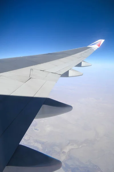 airplane wing porthole, blue sky, clouds outside the window. freedom of movement.