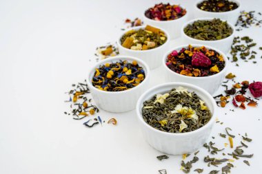 Beyaz arka planda, kâselerde çay çeşitleri. Makro çekim konseptini kapat. Sağlıklı, organik içecek.