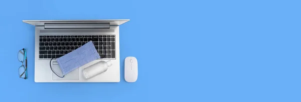 Ofis gereçleri hijyen pankartı. İşteki antibakteriyel dezenfeksiyon düzlemde. Laptop, bilgisayar, fare, tıbbi maske, antiseptik el dezenfektanı. Virüs koruma sağlık hizmetleri, evde kalmak, tecrit kavramı